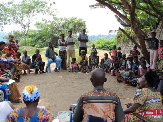 Discussing malnutrition in the shade of a mango tree.