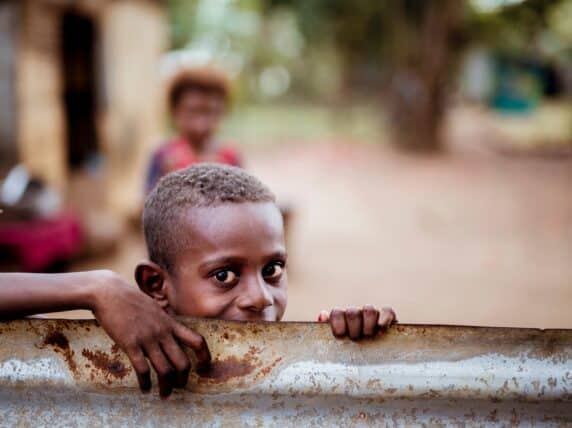 A boy looking over a metal sheet