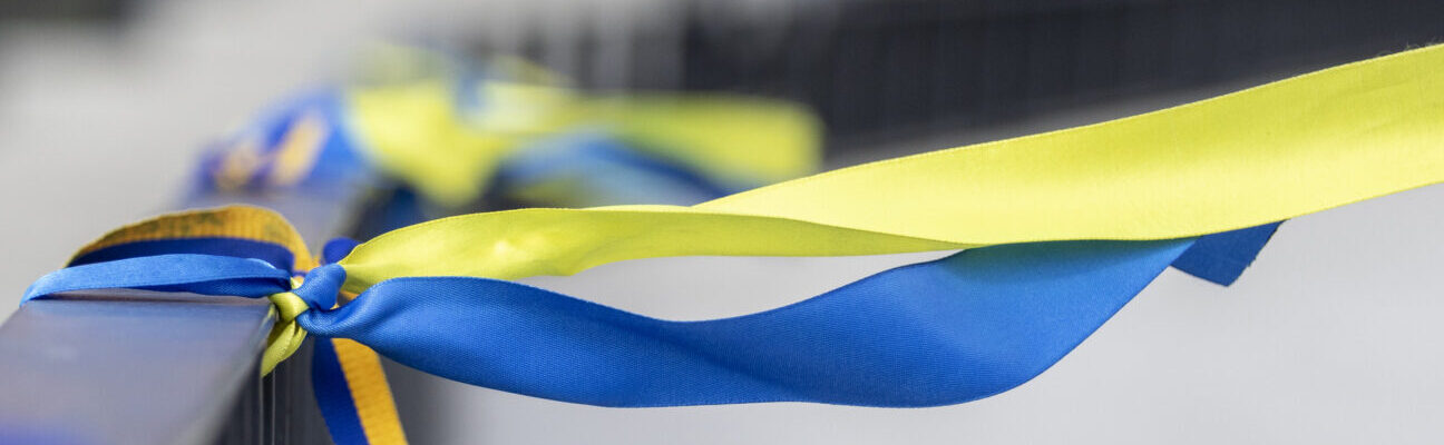 Ribbons in the colors of the national flag of Ukraine are tied to the handrail.