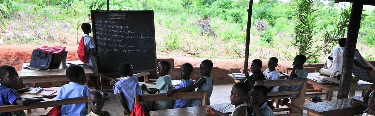 Students attending class in an outdoors elementary school classroom in the Yilo Krobo District near Accra, Ghana