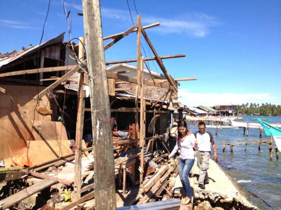 People through destroyed building after typhoon in Philippines