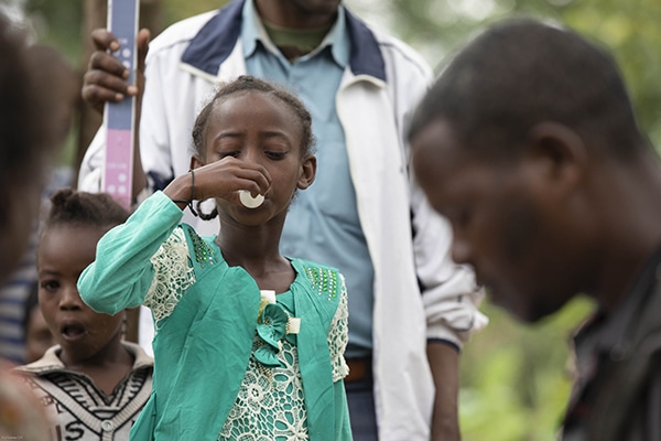 A young girl takes her antibiotics