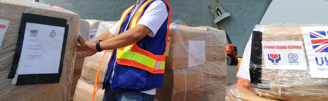 The Department for International Development’s (DFID) United Kingdom Aid (UKAid) unloads humanitarian aid in Manila. The pallets of shelter and repair kits, non-food items, and plant (including generators) came to the Philippines via HMS Illustrious, a 23,000-tonne aircraft carrier of the Royal Navy. © IOM 2013 / Ray Leyesa